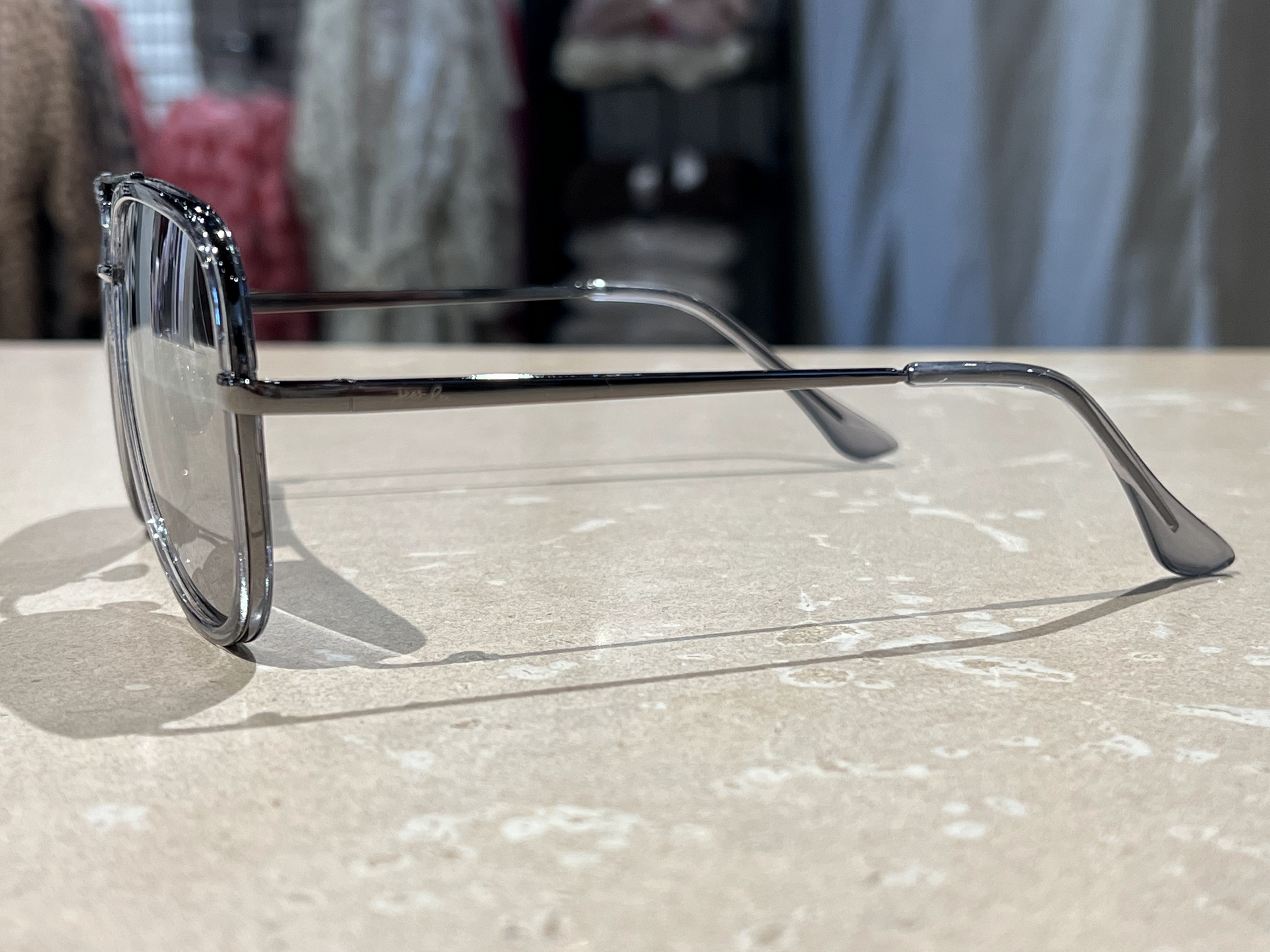 silver aviator sunglasses with thin round wireframes, tinted lenses, UV protection, and brand name detail (on both the temple and the complimentary black pouch)