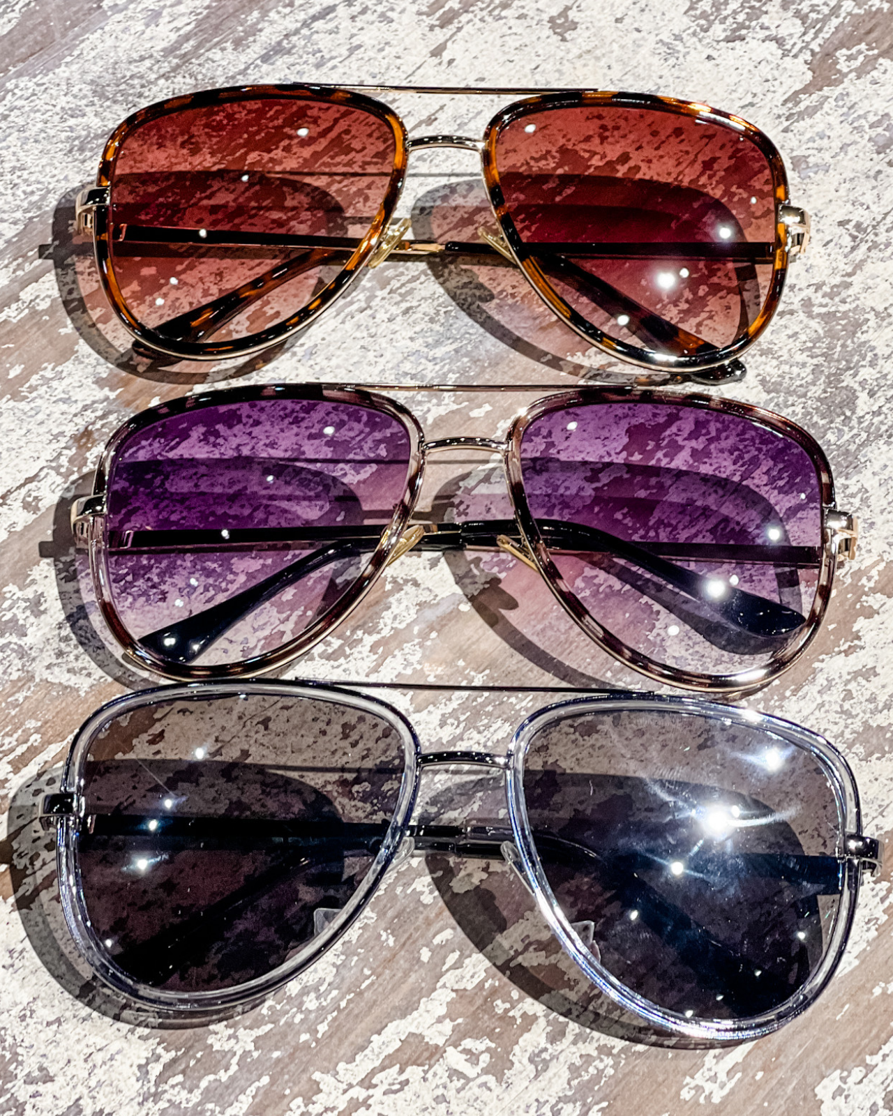 brown, grey, and silver aviator sunglasses with thin round wireframes, tinted lenses, UV protection, and brand name detail (on both the temple and the complimentary black pouch)