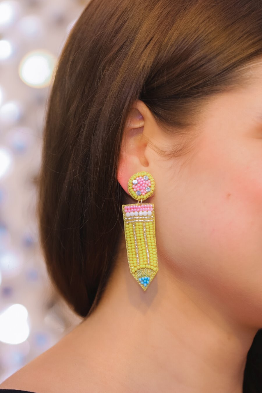 pencil-shaped stud earrings made of colorful beading and rhinestones with a felt backing, a comfort back earring, and a plastic disc stopper in gold
