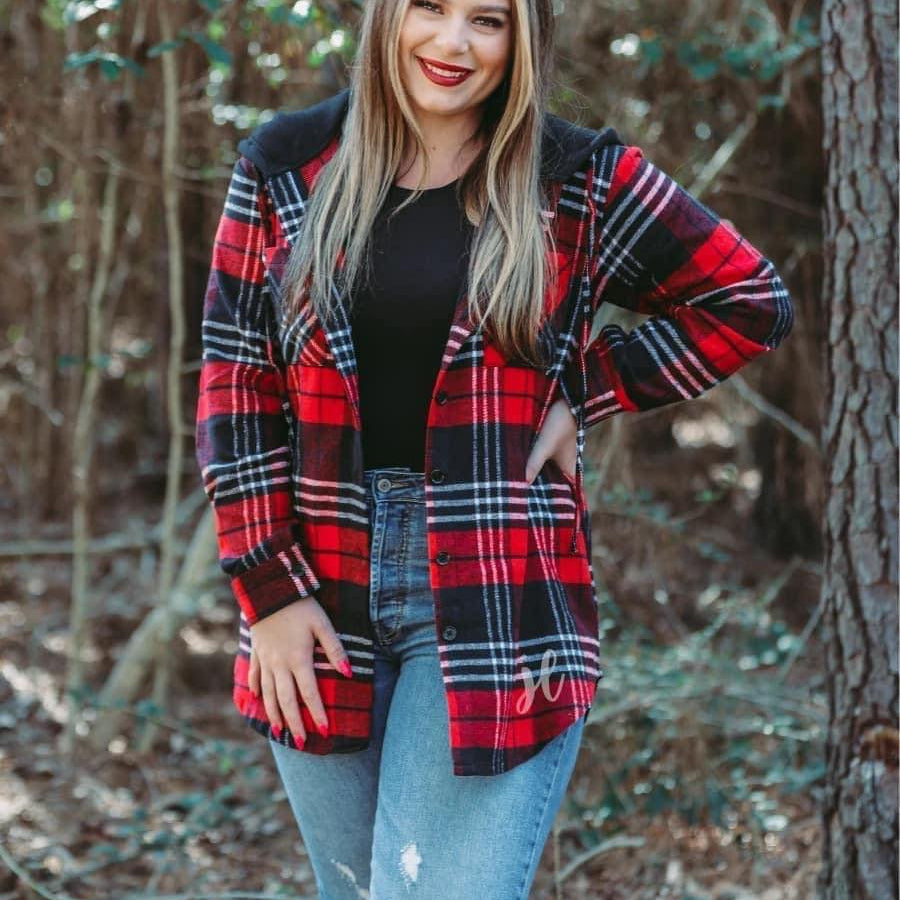 loose long sleeve shacket with fitted button closure cuffs, a button-down front, two chest pockets, a high-low hem, and a pull-string hood on a shirt material with a red plaid print