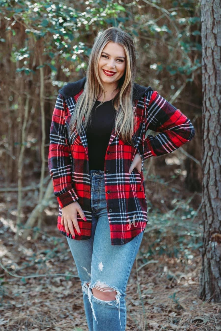 loose long sleeve shacket with fitted button closure cuffs, a button-down front, two chest pockets, a high-low hem, and a pull-string hood on a shirt material with a red plaid print