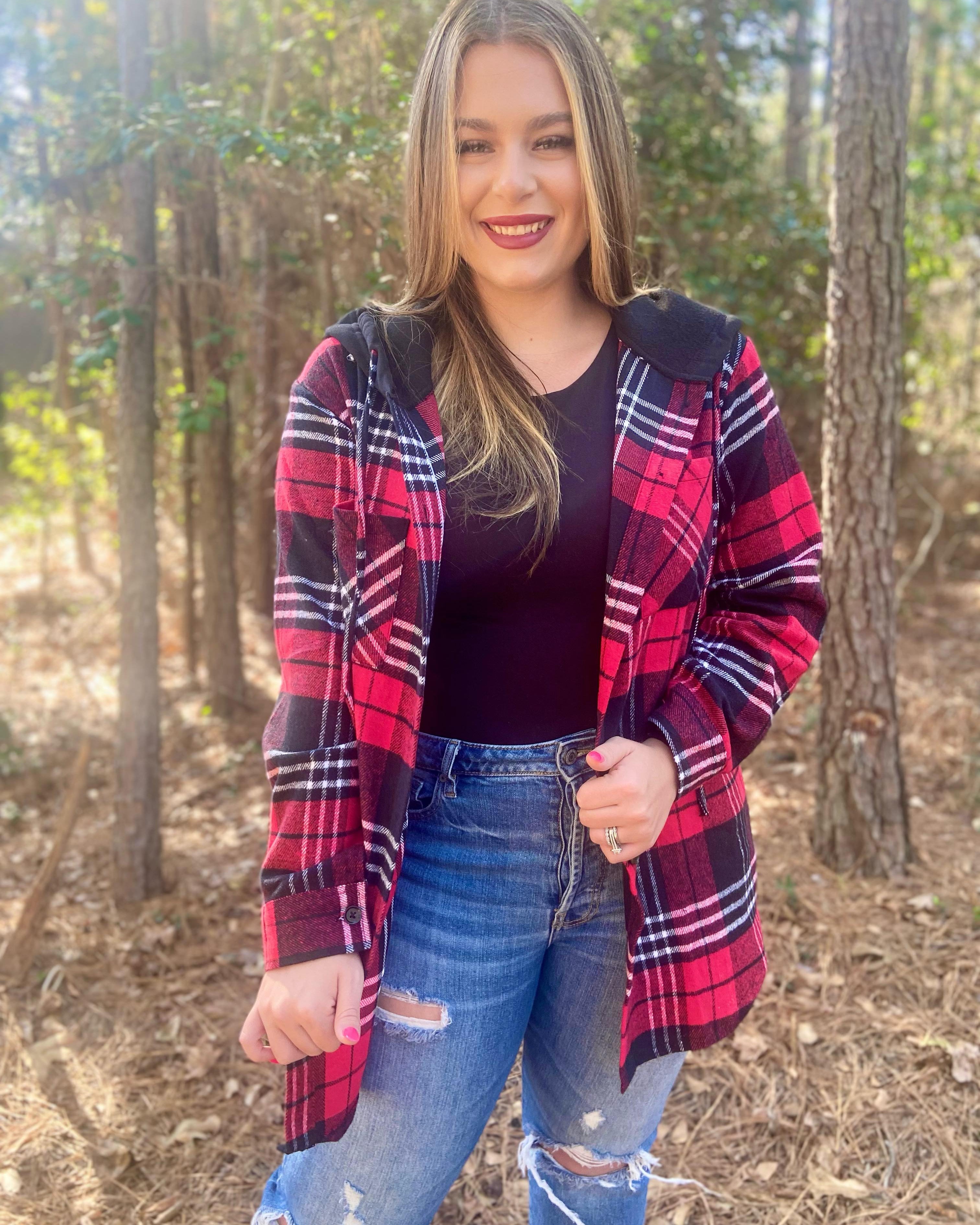 loose long sleeve shacket with fitted button closure cuffs, a button-down front, two chest pockets, a high-low hem, and a pull-string hood on a shirt material with a red plaid print