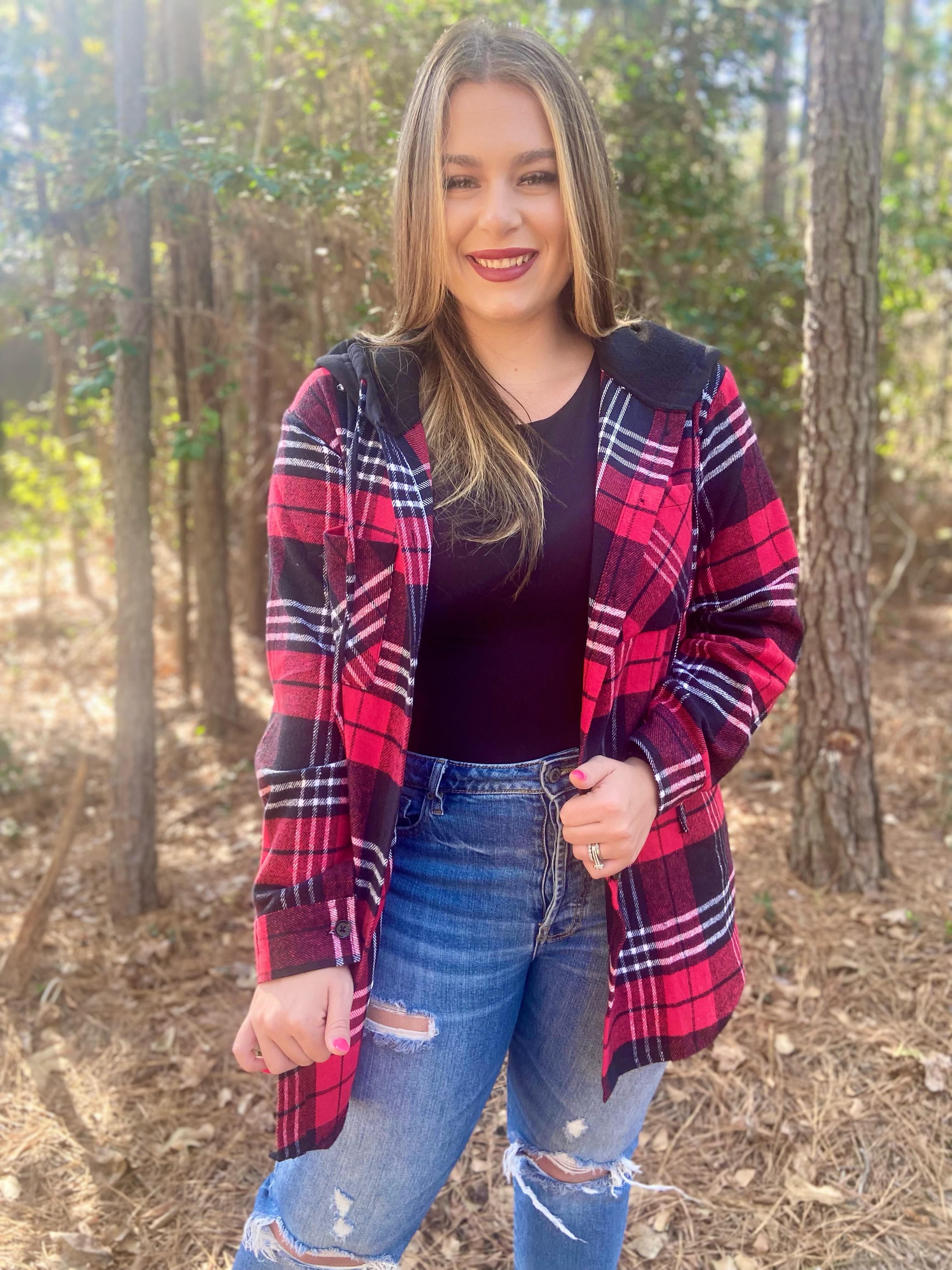 loose long sleeve shacket with fitted button closure cuffs, a button-down front, two chest pockets, a high-low hem, and a pull-string hood on a shirt material with a red plaid print