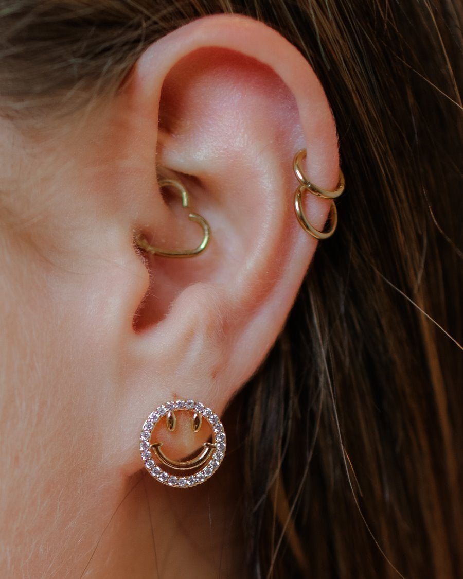 stud earrings in the shape of a gold happy face surrounded by sparkling rhinestones