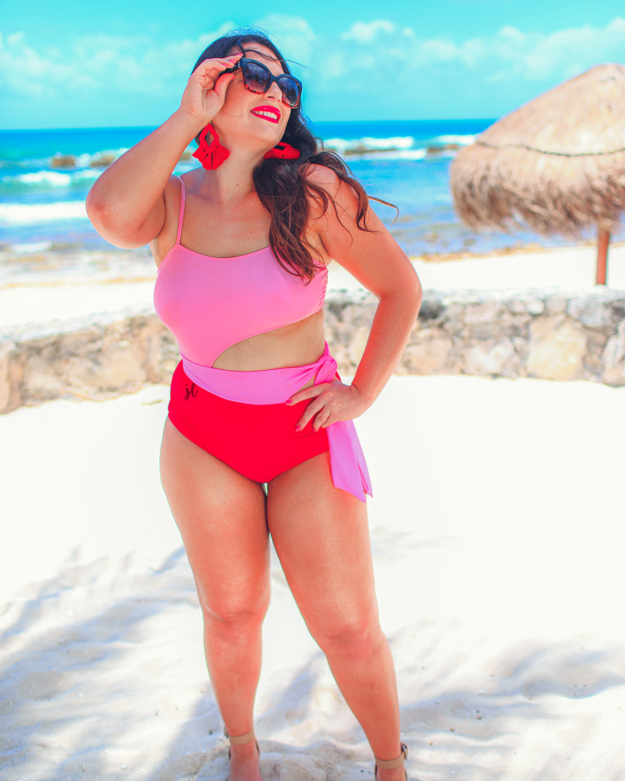 two-tone one-piece swimsuit made of stretchy material with adjustable spaghetti straps that can crisscross in back, a side cutout with a wraparound tie, and removable padding