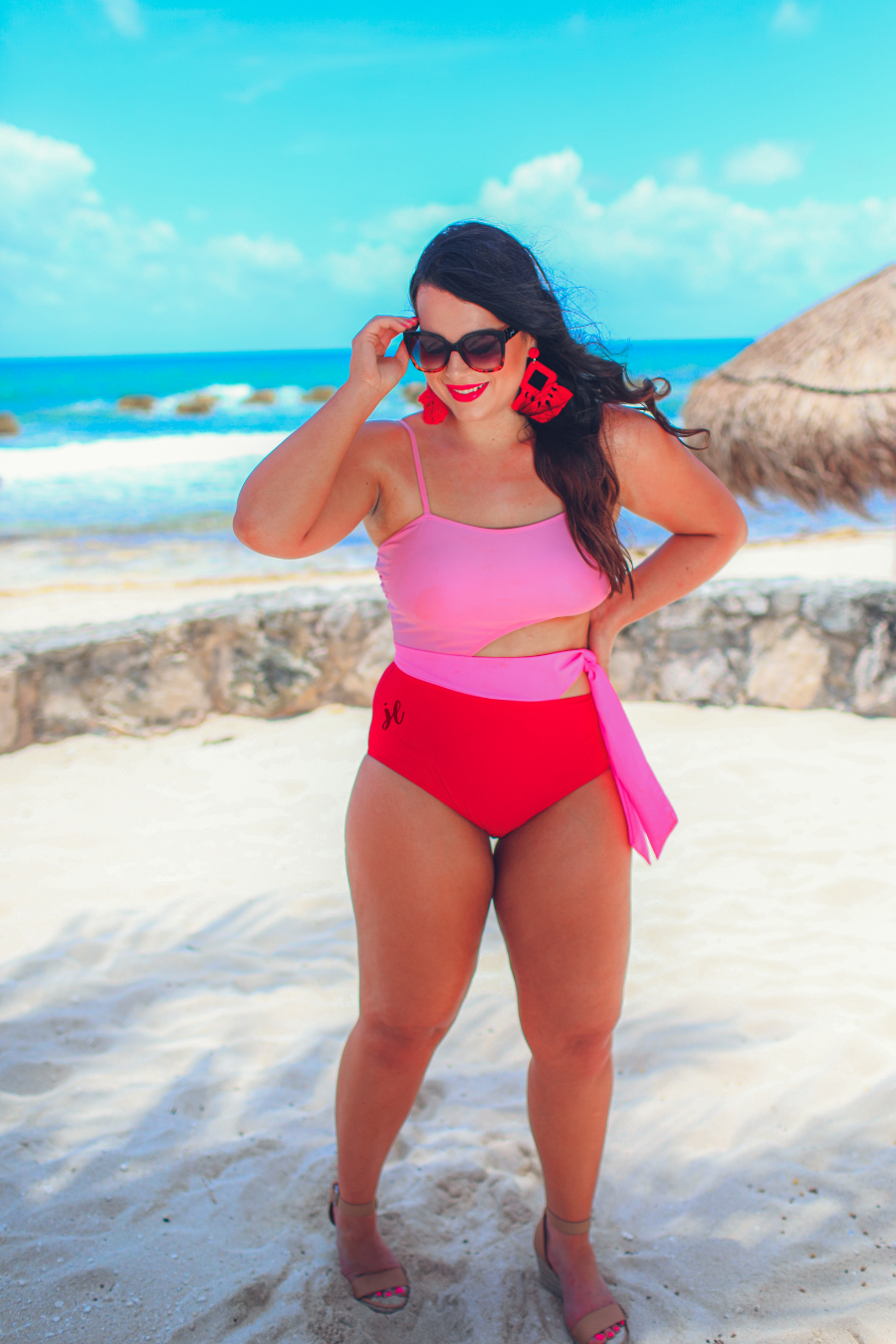 two-tone one-piece swimsuit made of stretchy material with adjustable spaghetti straps that can crisscross in back, a side cutout with a wraparound tie, and removable padding