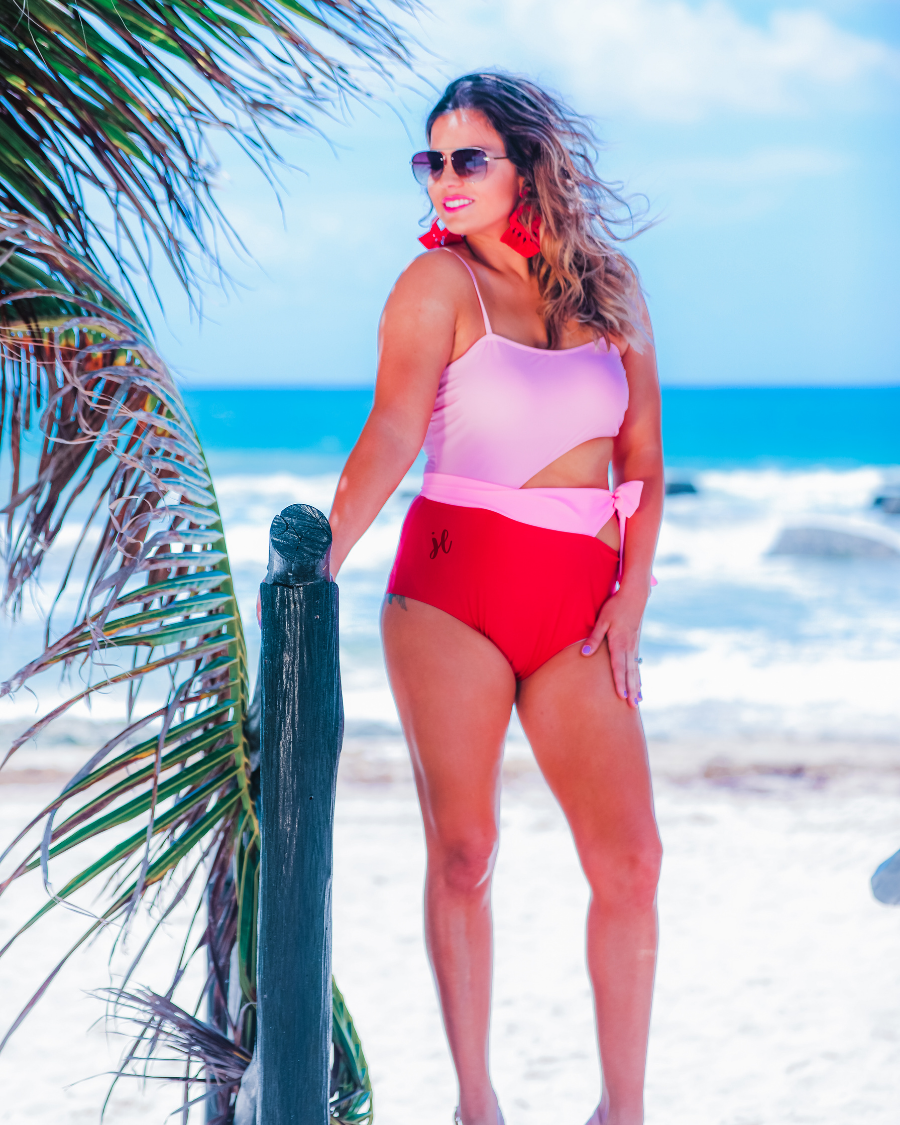two-tone one-piece swimsuit made of stretchy material with adjustable spaghetti straps that can crisscross in back, a side cutout with a wraparound tie, and removable padding
