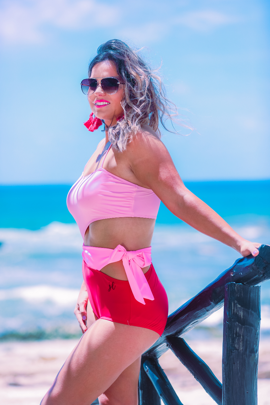 two-tone one-piece swimsuit made of stretchy material with adjustable spaghetti straps that can crisscross in back, a side cutout with a wraparound tie, and removable padding