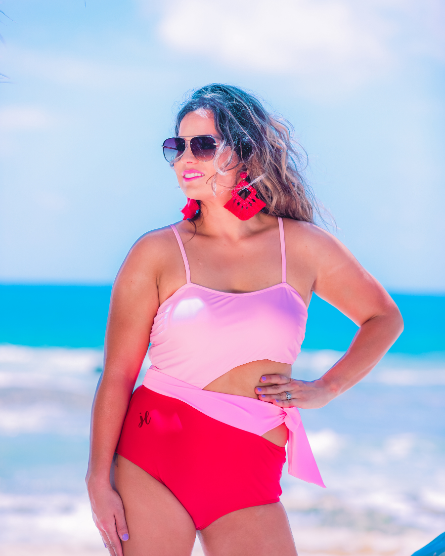 two-tone one-piece swimsuit made of stretchy material with adjustable spaghetti straps that can crisscross in back, a side cutout with a wraparound tie, and removable padding