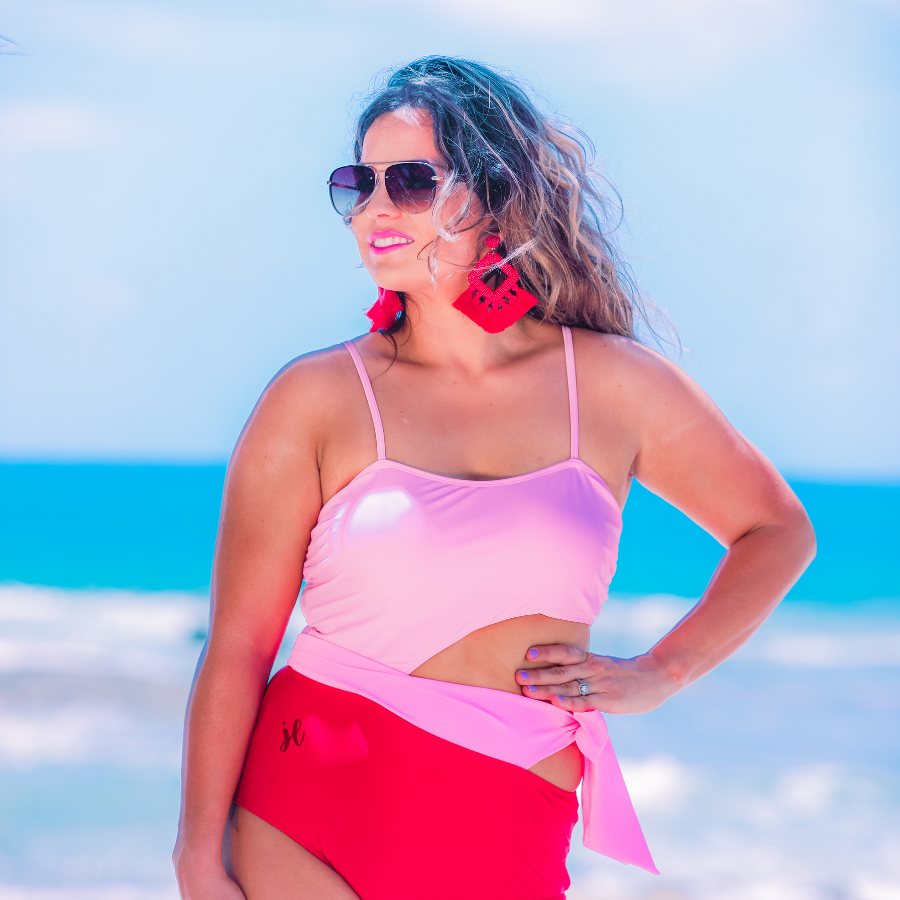 two-tone one-piece swimsuit made of stretchy material with adjustable spaghetti straps that can crisscross in back, a side cutout with a wraparound tie, and removable padding