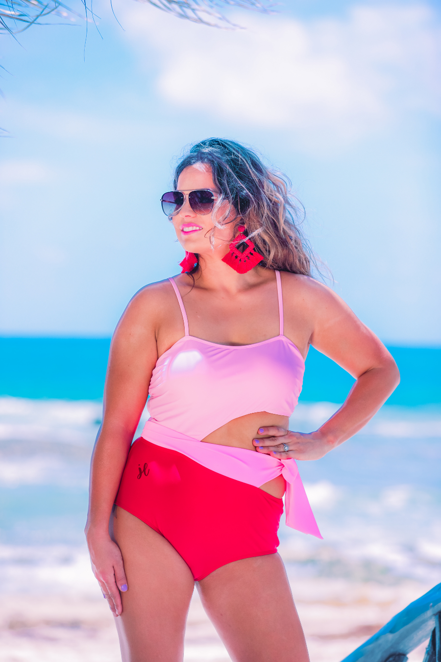 two-tone one-piece swimsuit made of stretchy material with adjustable spaghetti straps that can crisscross in back, a side cutout with a wraparound tie, and removable padding