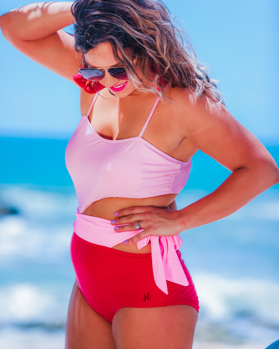 two-tone one-piece swimsuit made of stretchy material with adjustable spaghetti straps that can crisscross in back, a side cutout with a wraparound tie, and removable padding