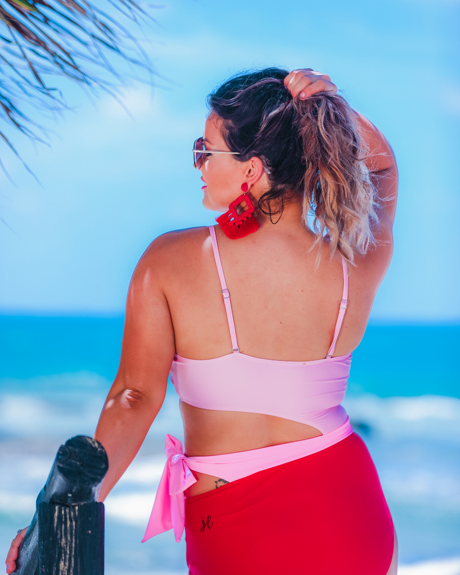 two-tone one-piece swimsuit made of stretchy material with adjustable spaghetti straps that can crisscross in back, a side cutout with a wraparound tie, and removable padding