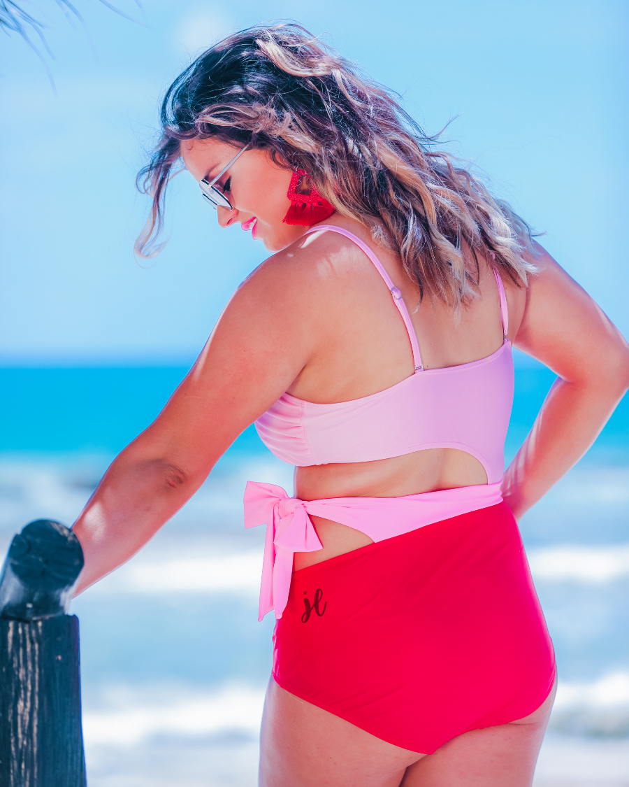 two-tone one-piece swimsuit made of stretchy material with adjustable spaghetti straps that can crisscross in back, a side cutout with a wraparound tie, and removable padding