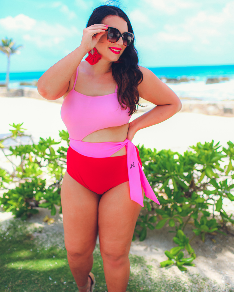 two-tone one-piece swimsuit made of stretchy material with adjustable spaghetti straps that can crisscross in back, a side cutout with a wraparound tie, and removable padding
