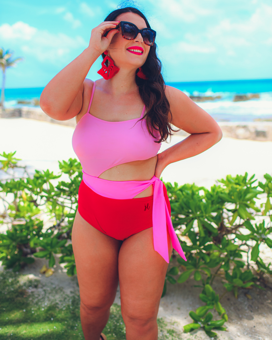 two-tone one-piece swimsuit made of stretchy material with adjustable spaghetti straps that can crisscross in back, a side cutout with a wraparound tie, and removable padding