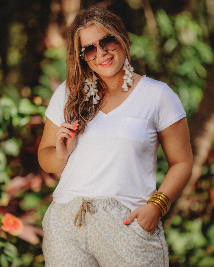 mid-rise relaxed fit activewear shorts with side pockets and a tie waist drawstring with gold bead accents, designed on a neutral leopard pattern print fabric, cream base, and beige trim