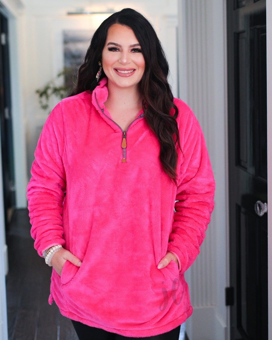 long-sleeve plush fleece pullover with quarter zip, front pockets, and a foldable collar on a super soft hot pink fabric