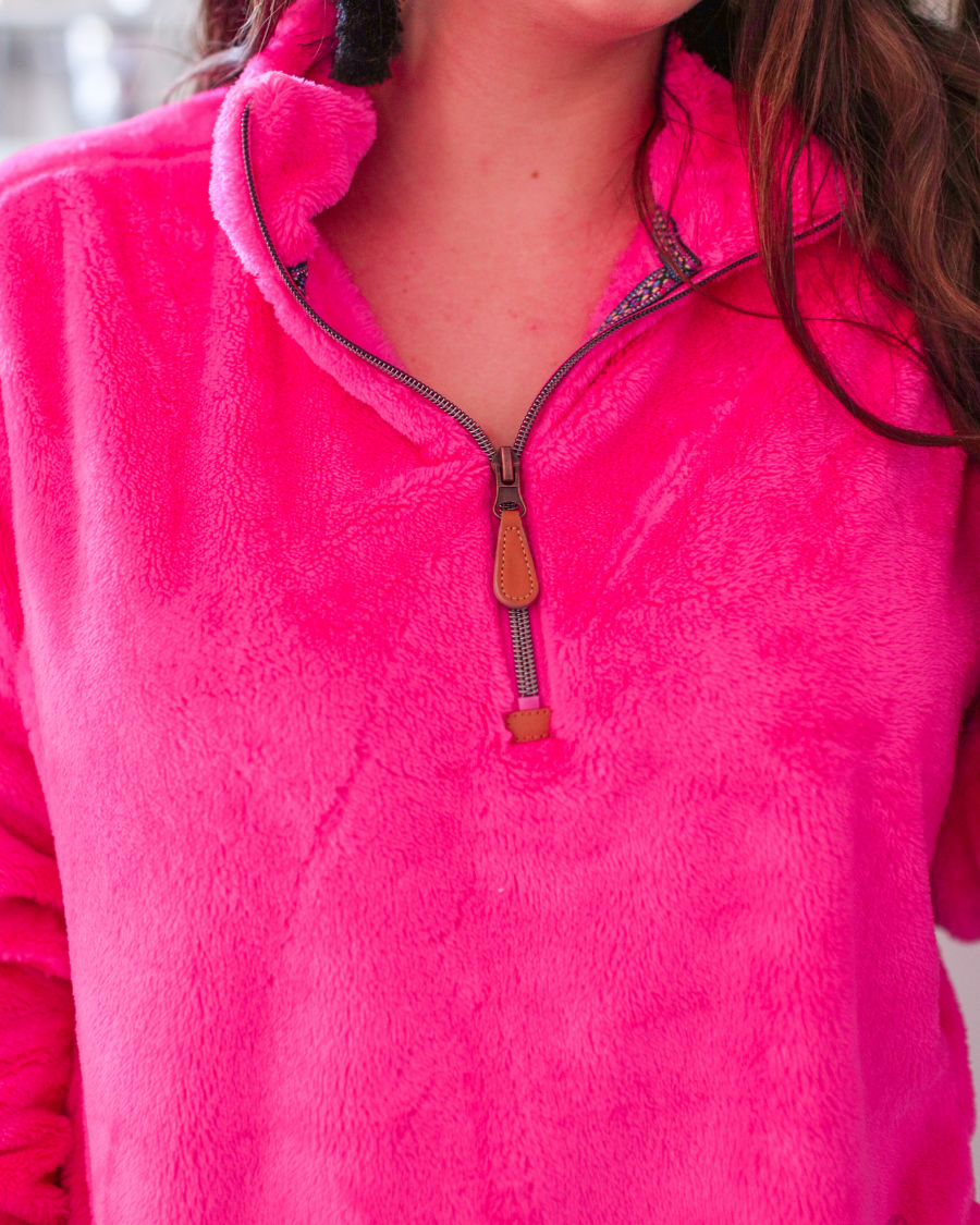 long-sleeve plush fleece pullover with quarter zip, front pockets, and a foldable collar on a super soft hot pink fabric