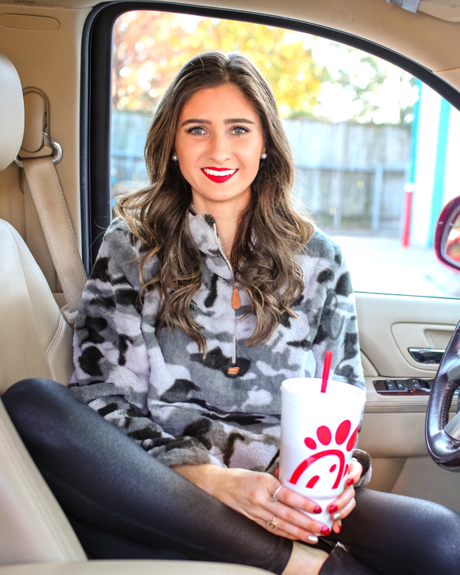 a long-sleeve luxurious faux fur material with a quarter zip, front pockets, and a foldable collar on a camouflage pattern fabric