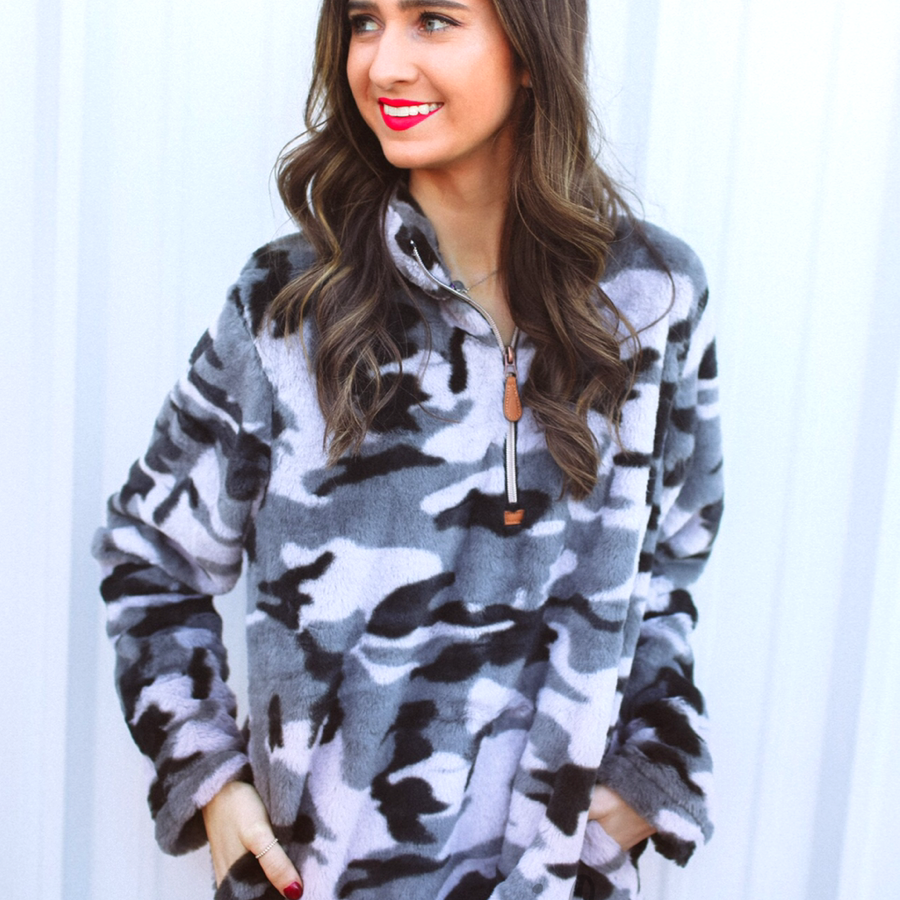 a long-sleeve luxurious faux fur material with a quarter zip, front pockets, and a foldable collar on a camouflage pattern fabric