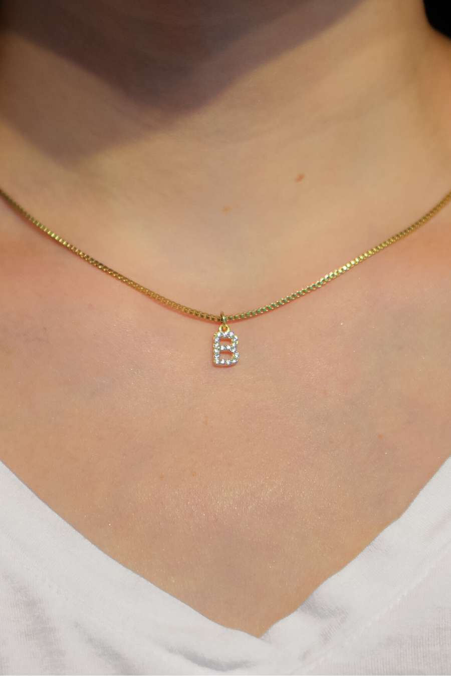 gold chain necklace with rhinestone-studded 'B' initial charm