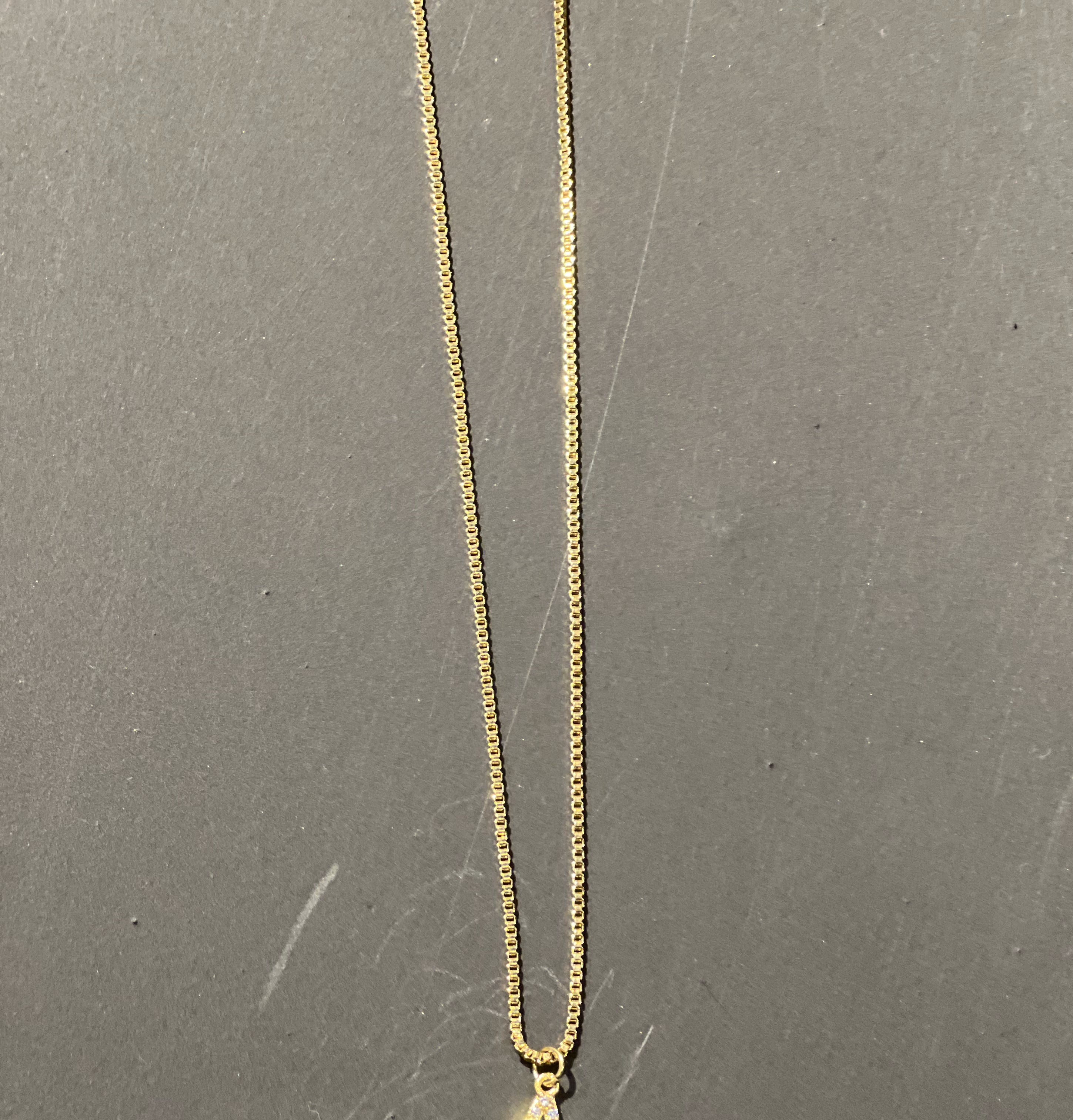 gold chain necklace with rhinestone-studded 'A' initial charm
