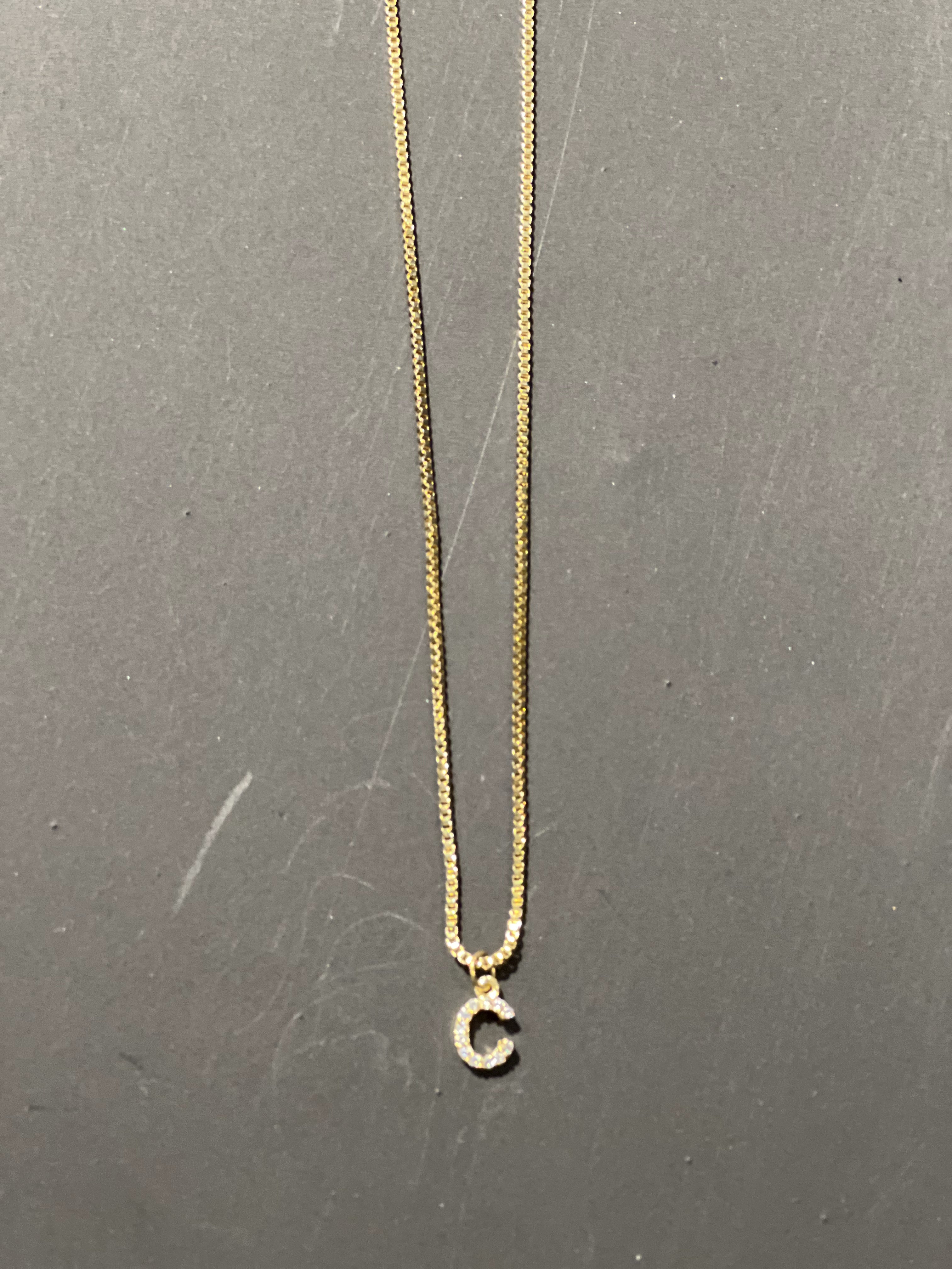 gold chain necklace with rhinestone-studded 'C' initial charm
