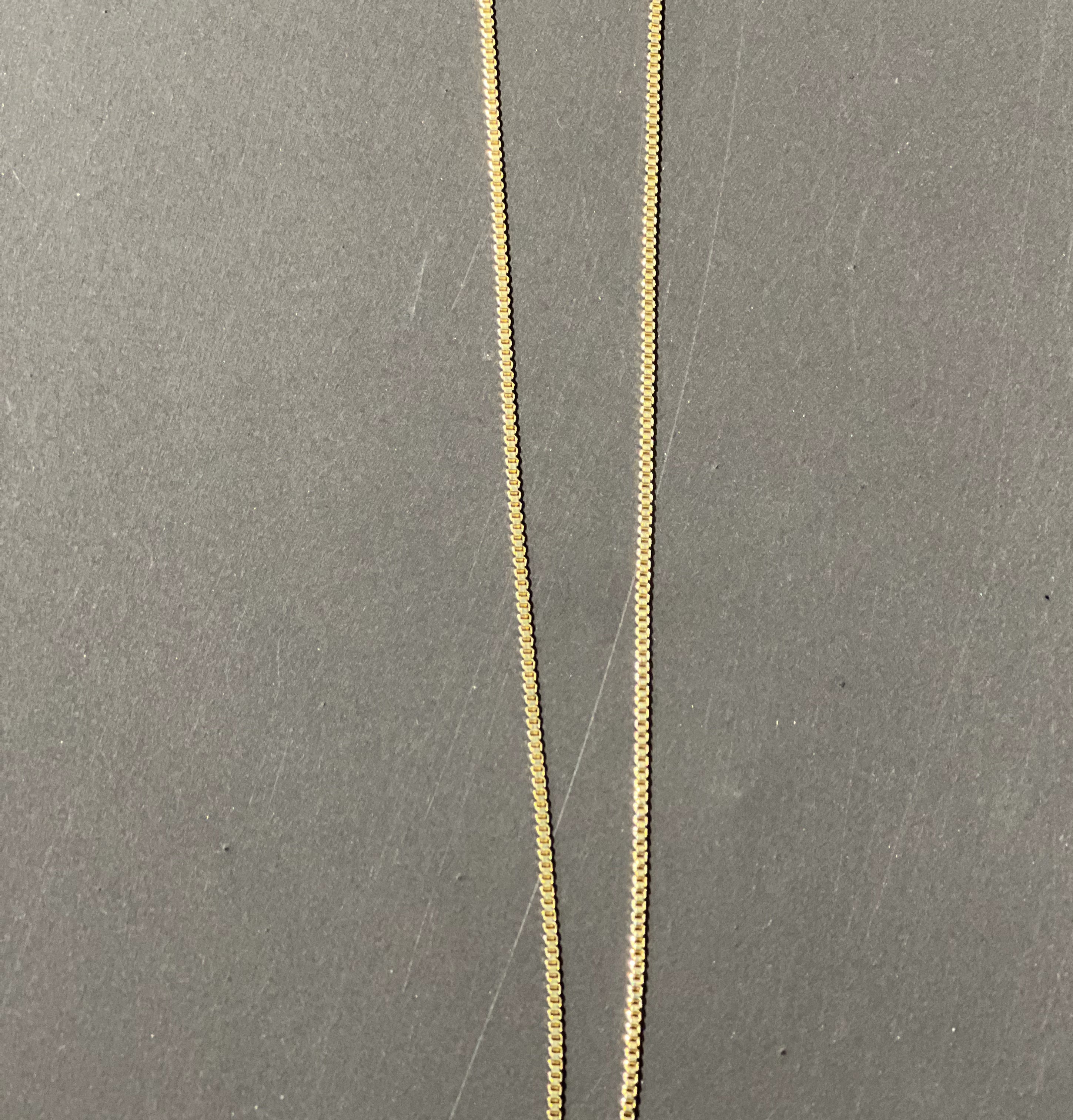 gold chain necklace with rhinestone-studded 'E' initial charm