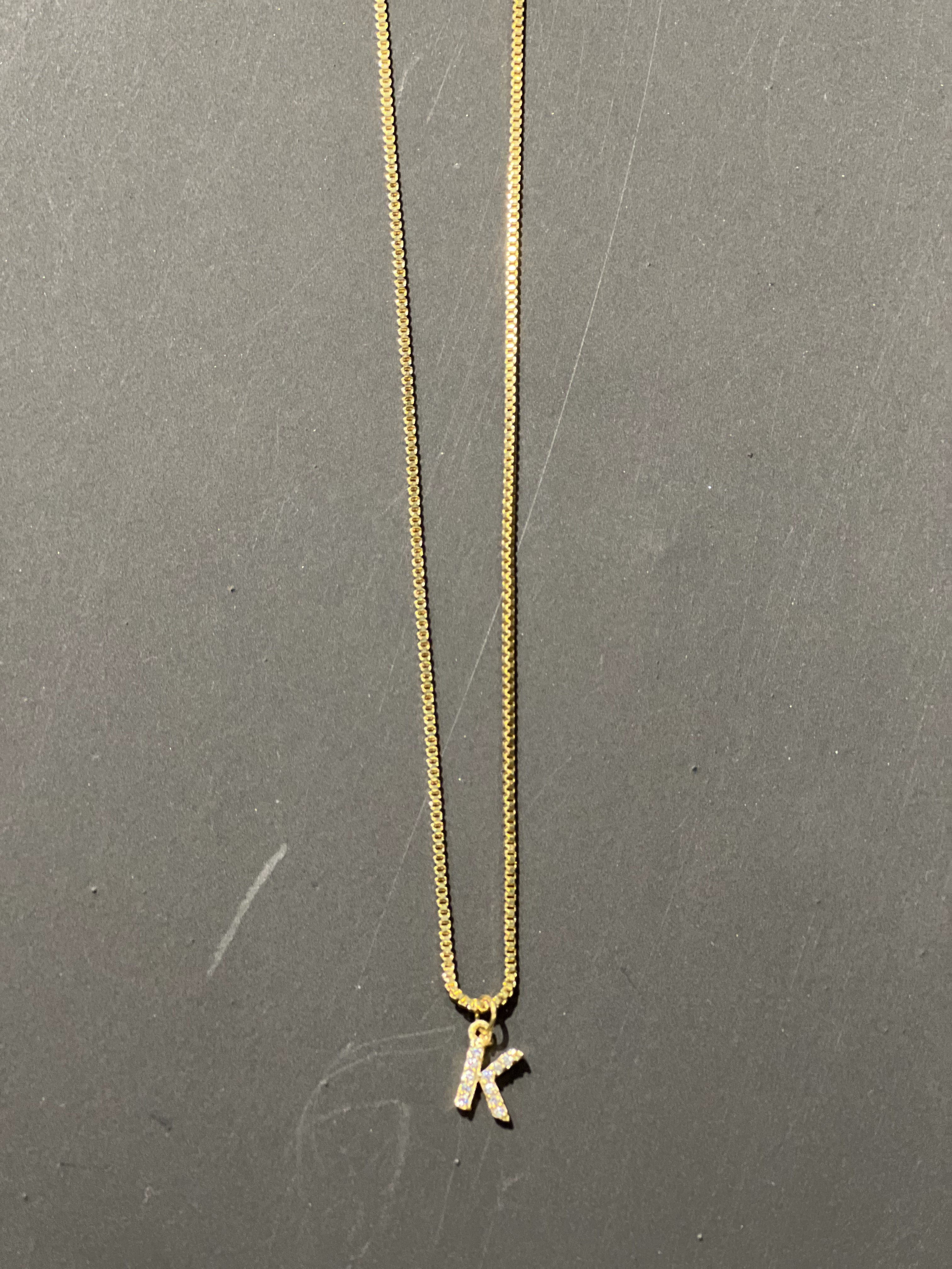 gold chain necklace with rhinestone-studded 'K' initial charm