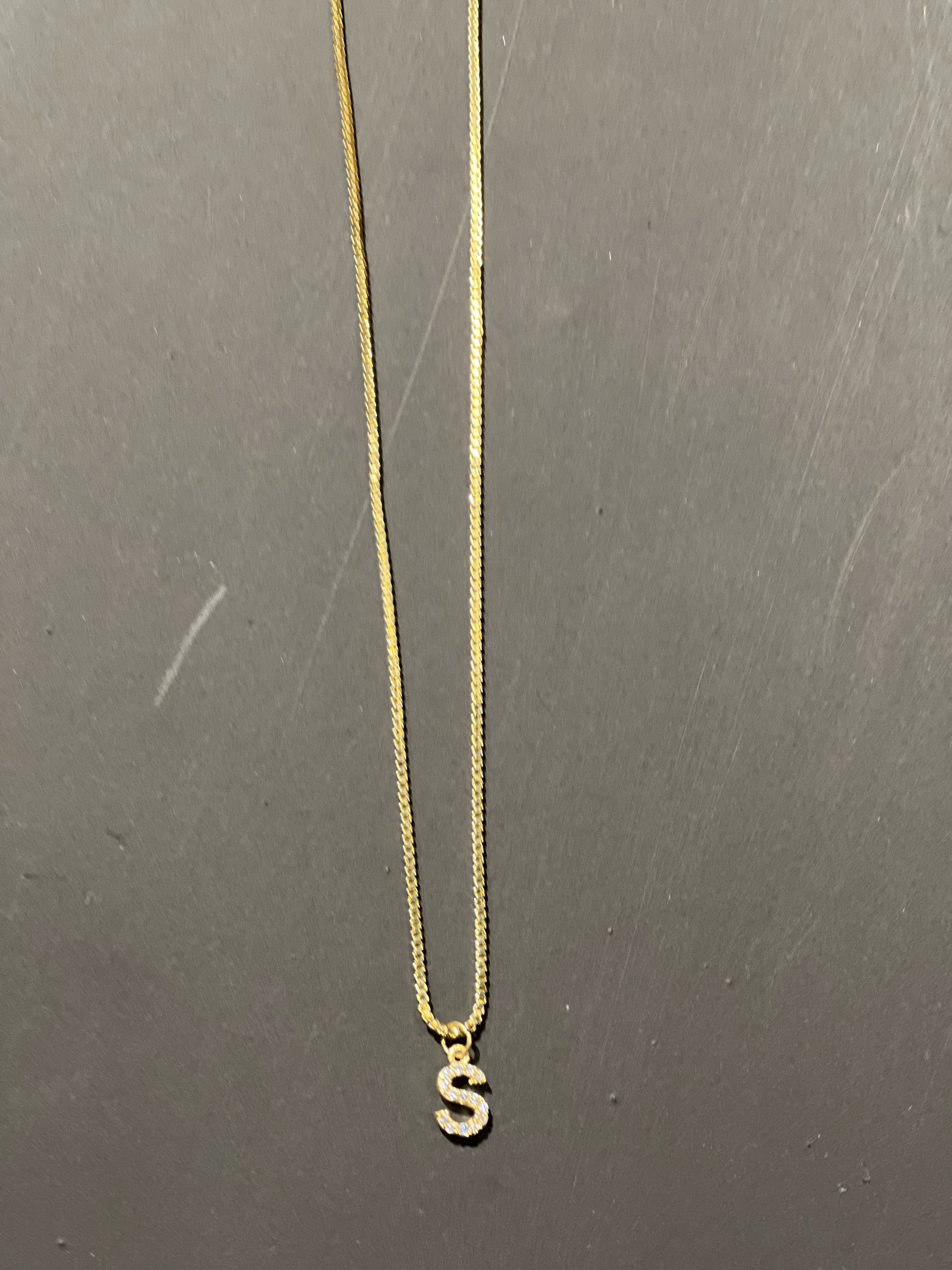 gold chain necklace with rhinestone-studded 'S' initial charm