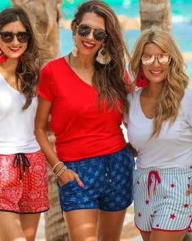 mid-rise relaxed fit activewear shorts with side pockets and a tie waist drawstring with gold bead accent on a blue star patterned fabric and blue trim