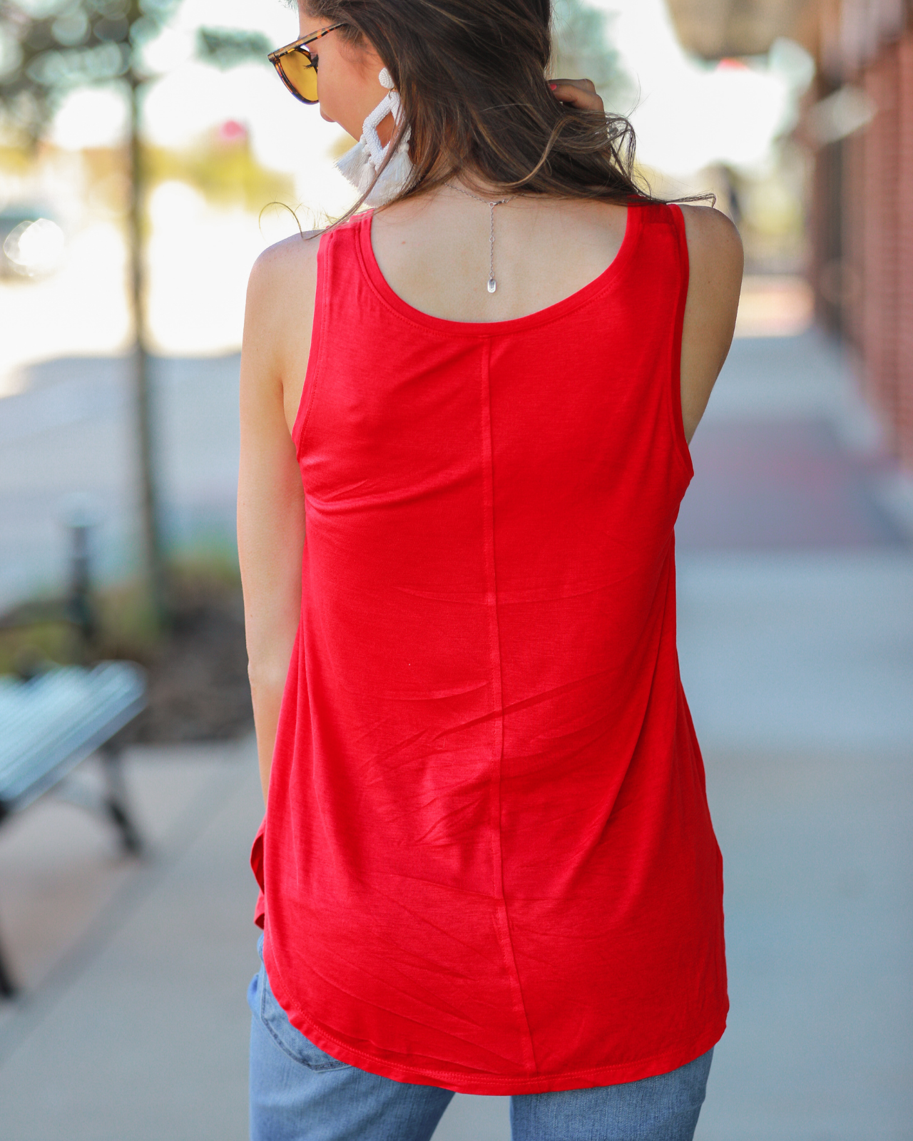 a sleeveless style tank with a v-neck neckline, side slits, a back center seam, and a rounded hi-lo hemline in red