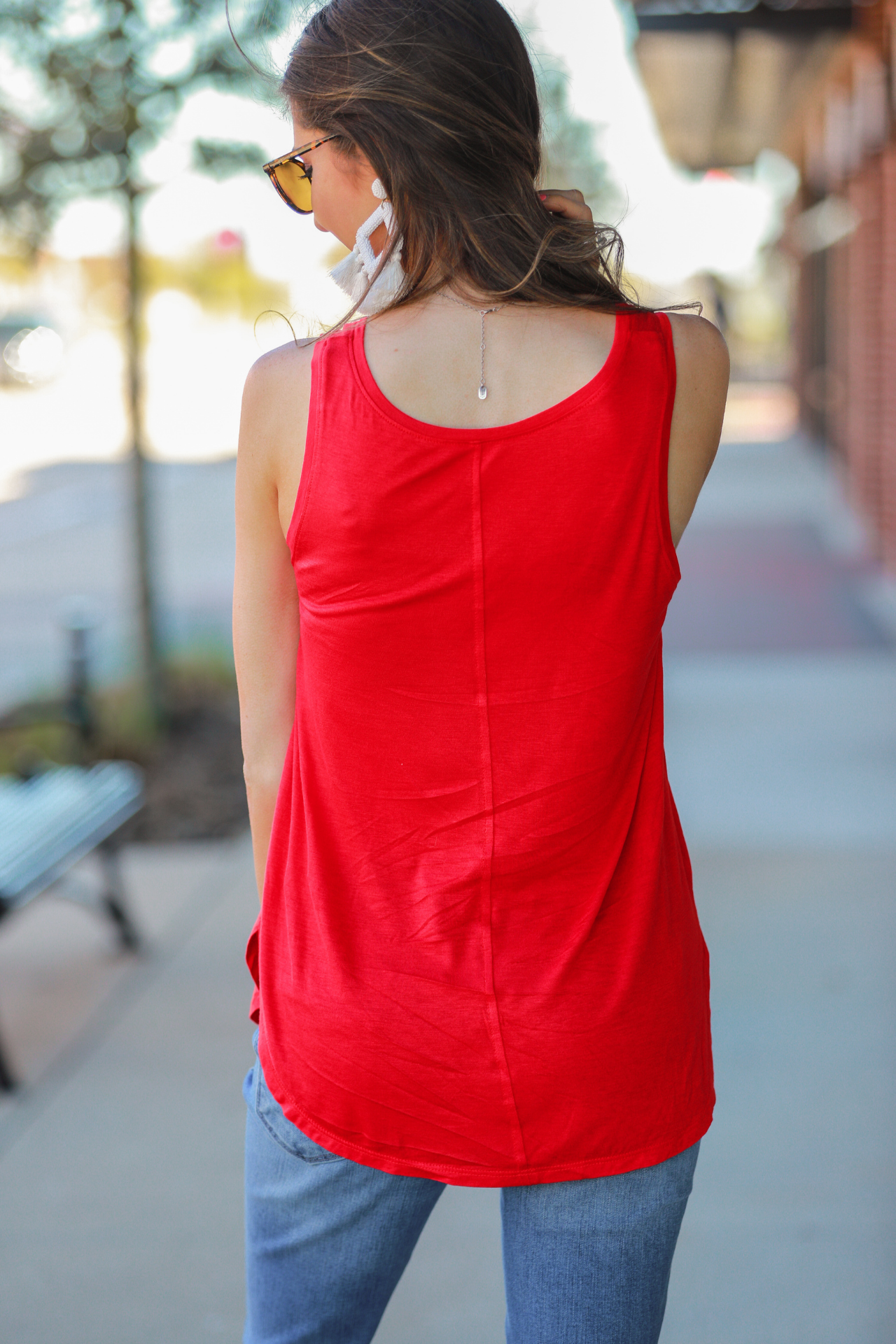 a sleeveless style tank with a v-neck neckline, side slits, a back center seam, and a rounded hi-lo hemline in red