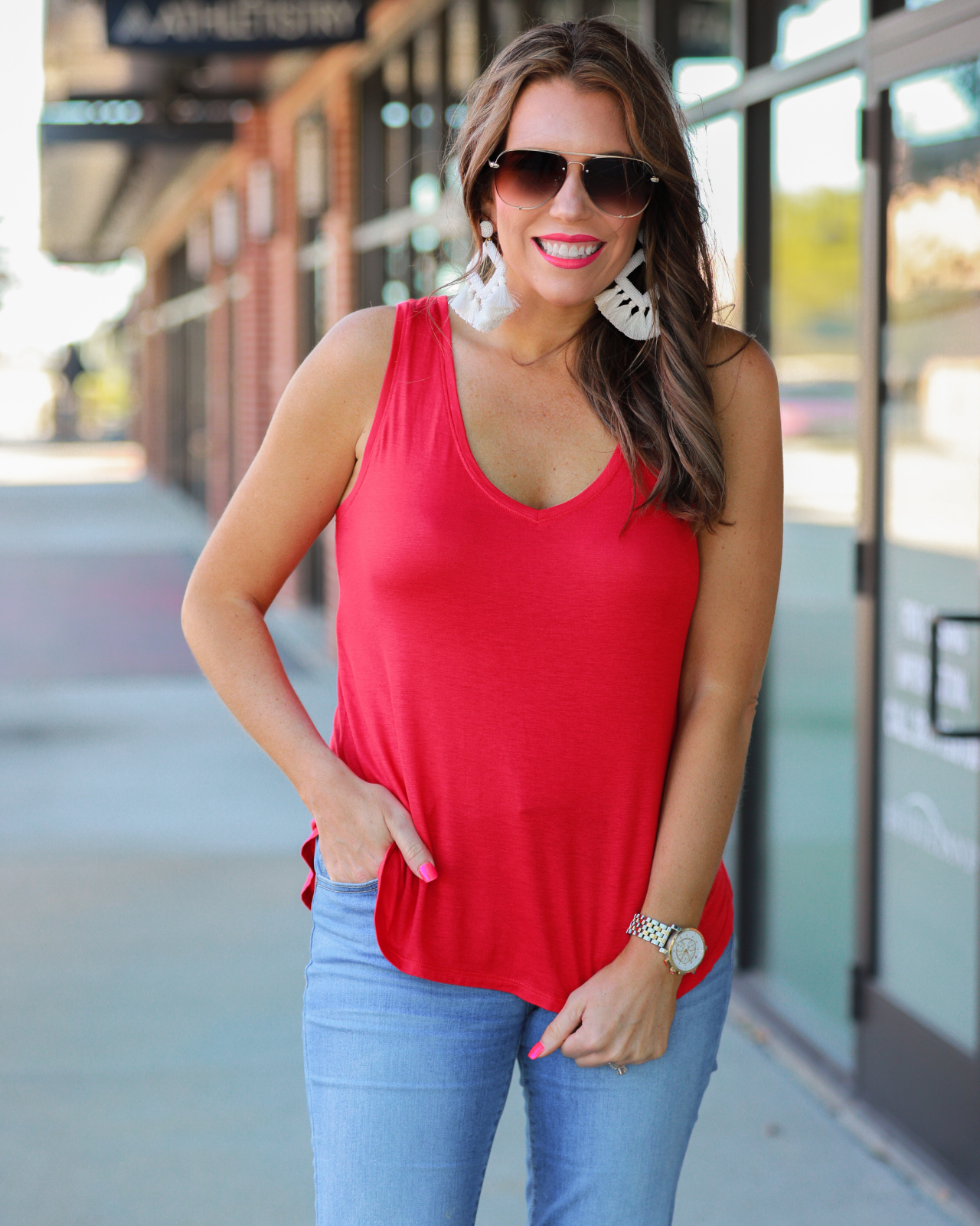a sleeveless style tank with a v-neck neckline, side slits, a back center seam, and a rounded hi-lo hemline in red