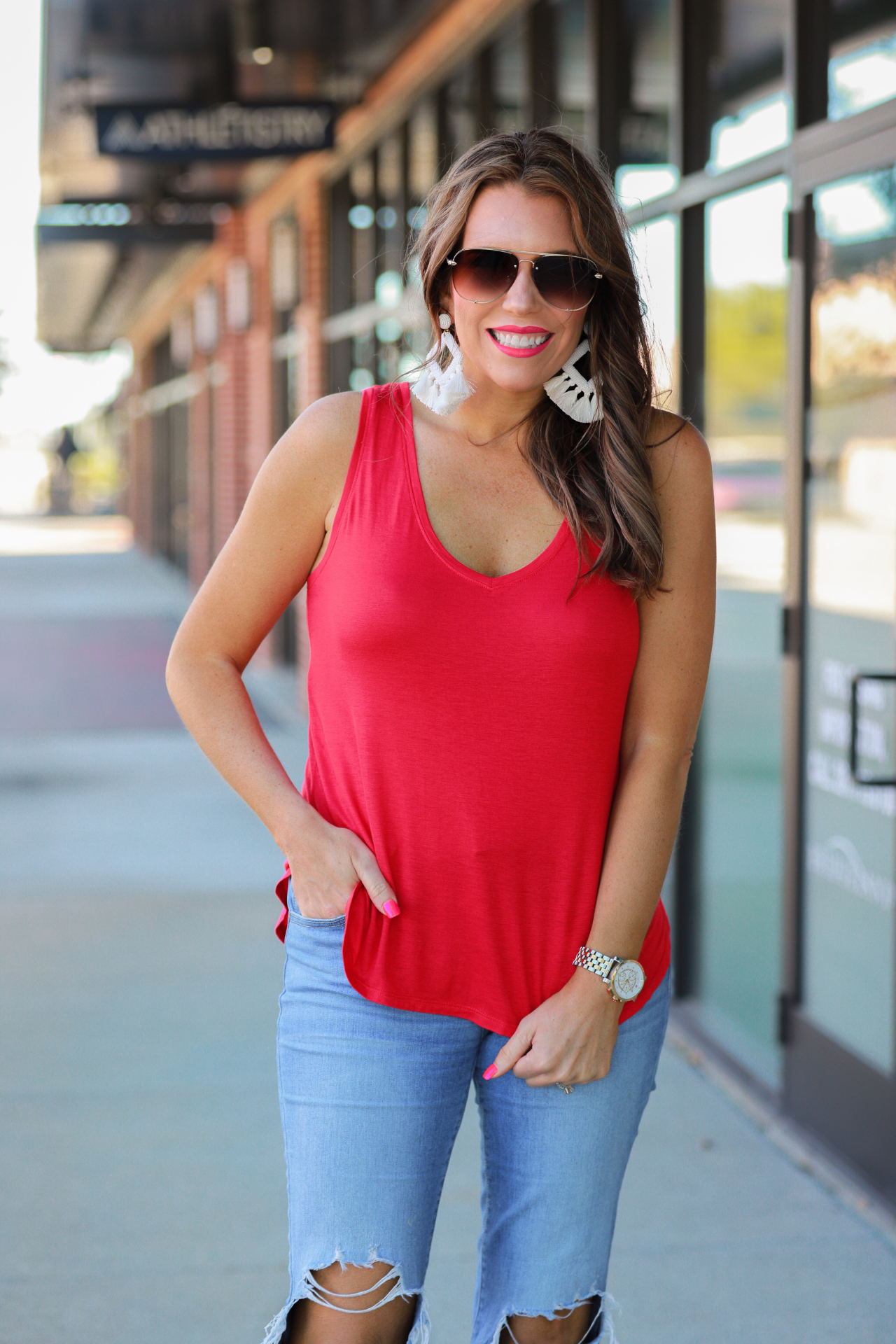 a sleeveless style tank with a v-neck neckline, side slits, a back center seam, and a rounded hi-lo hemline in red