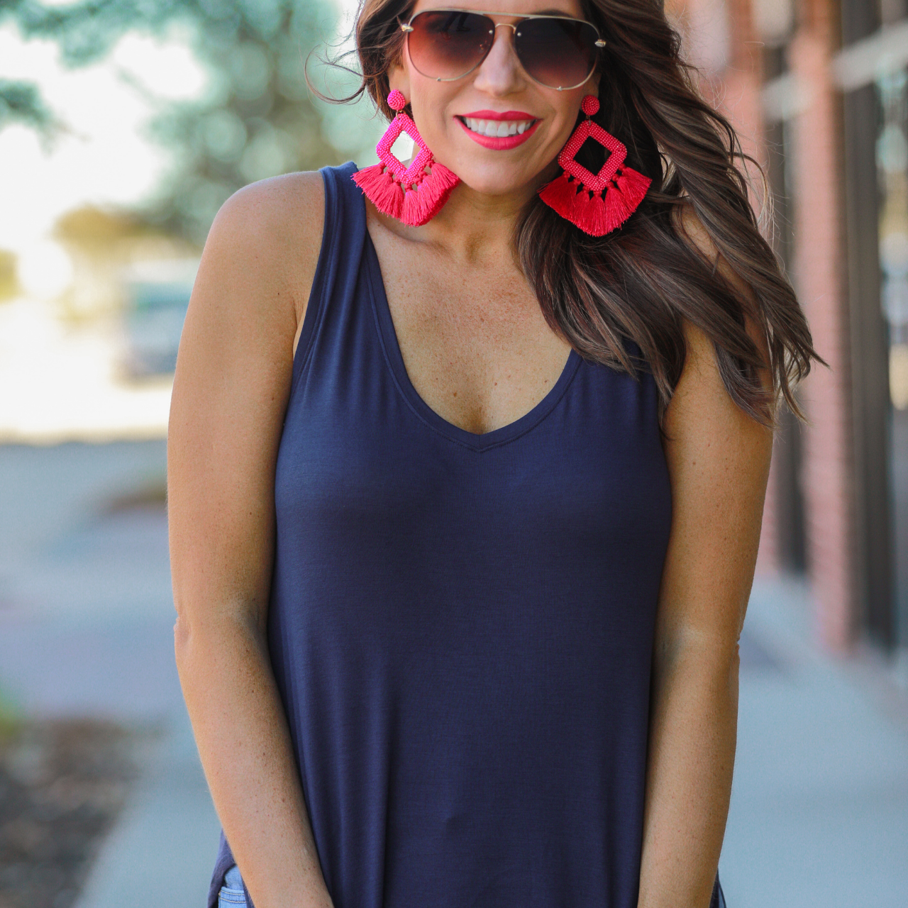 a sleeveless style tank with a v-neck neckline, side slits, a back center seam, and a rounded hi-lo hemline in navy