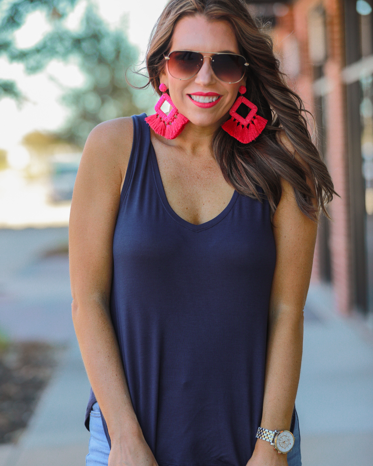 a sleeveless style tank with a v-neck neckline, side slits, a back center seam, and a rounded hi-lo hemline in navy