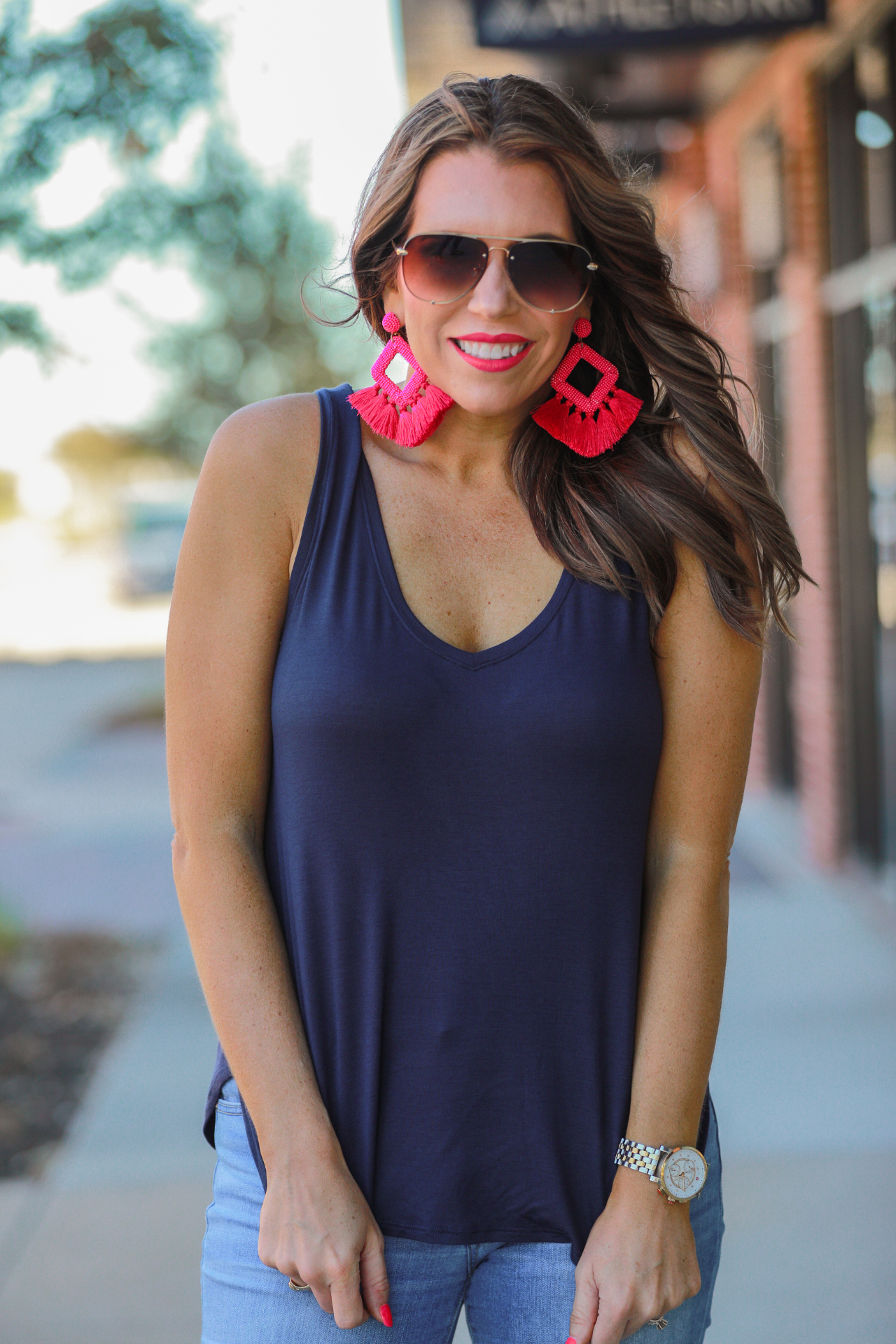 a sleeveless style tank with a v-neck neckline, side slits, a back center seam, and a rounded hi-lo hemline in navy
