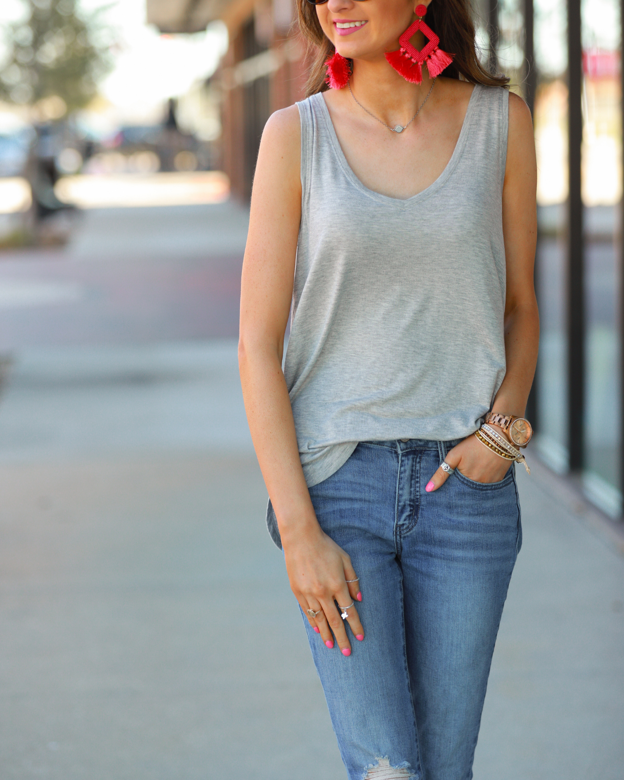 a sleeveless style tank with a v-neck neckline, side slits, a back center seam, and a rounded hi-lo hemline in grey