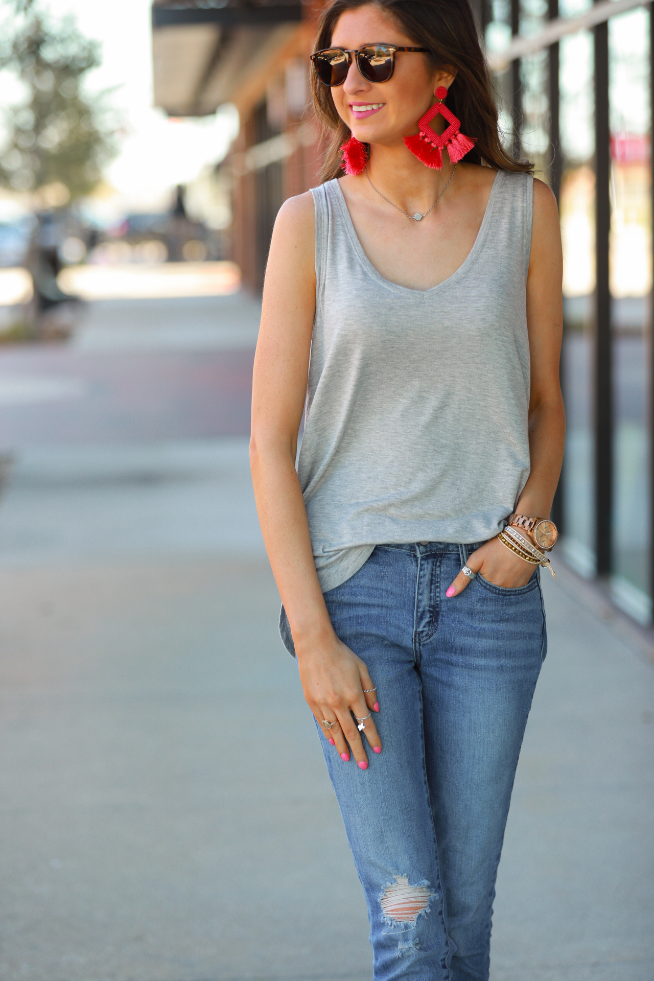 a sleeveless style tank with a v-neck neckline, side slits, a back center seam, and a rounded hi-lo hemline in grey