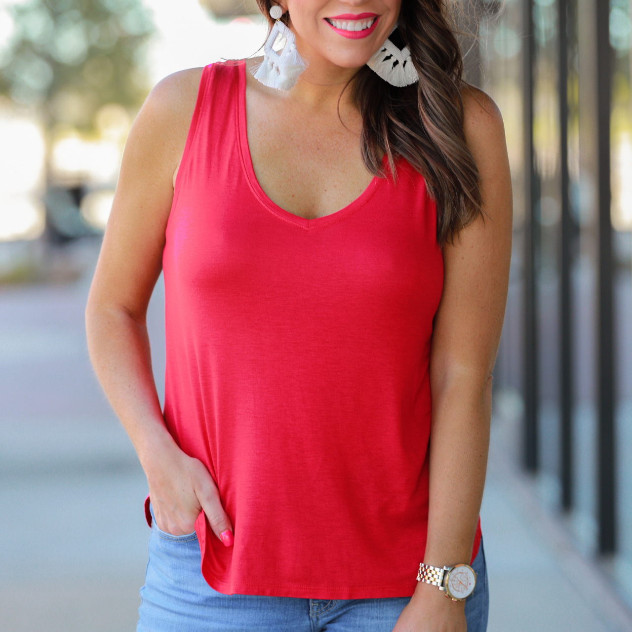 a sleeveless style tank with a v-neck neckline, side slits, a back center seam, and a rounded hi-lo hemline in red