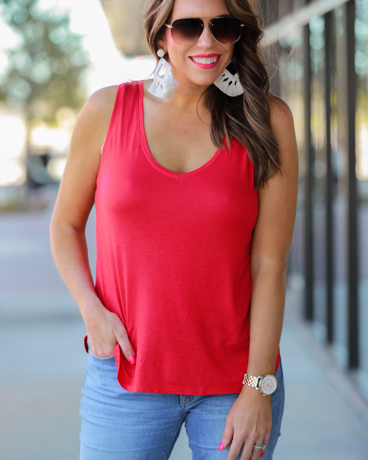 a sleeveless style tank with a v-neck neckline, side slits, a back center seam, and a rounded hi-lo hemline in red