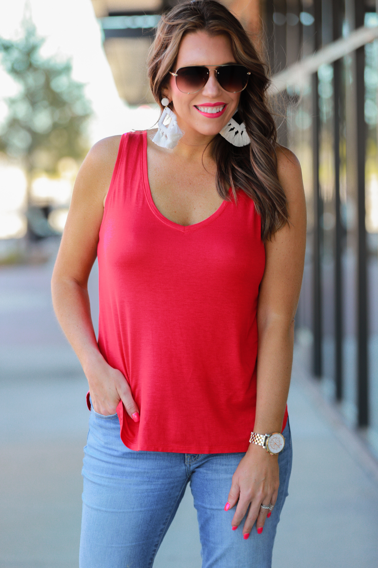 a sleeveless style tank with a v-neck neckline, side slits, a back center seam, and a rounded hi-lo hemline in red