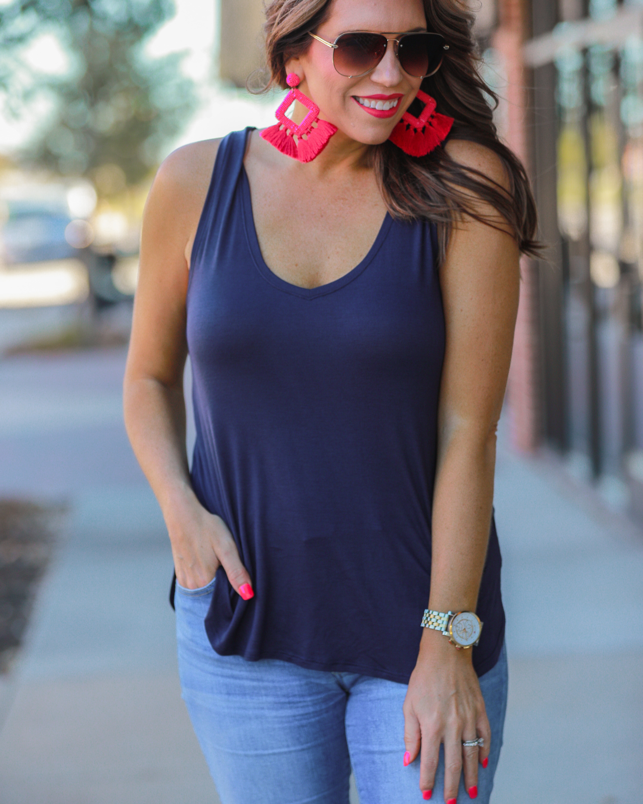 a sleeveless style tank with a v-neck neckline, side slits, a back center seam, and a rounded hi-lo hemline in navy