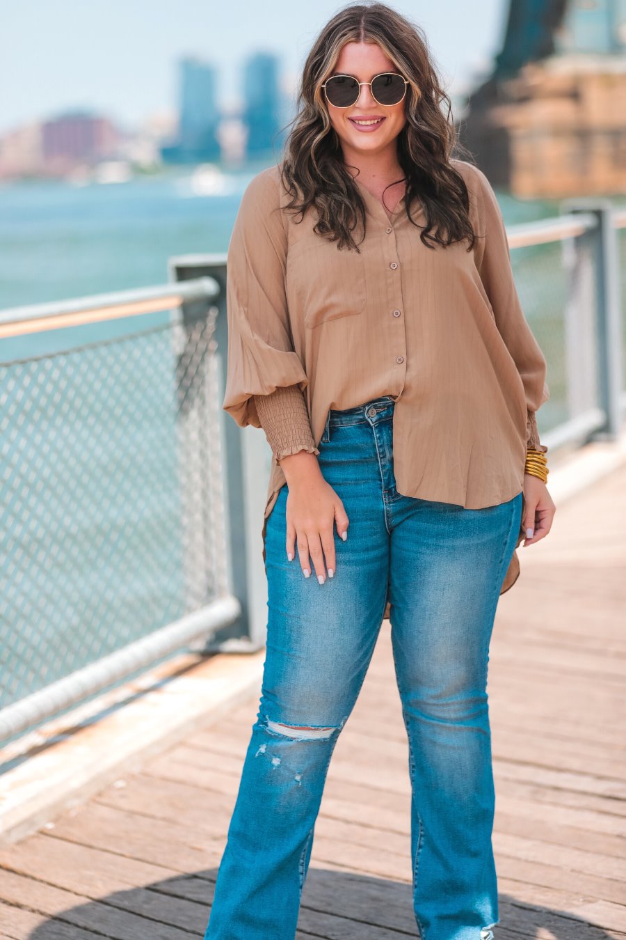 long-sleeve unlined top with a collared neckline, smocked wrists, button down front closure, functional side pockets, a chest pocket, a high-low hemline, and a relaxed fit designed on vertical stripe fabric in taupe