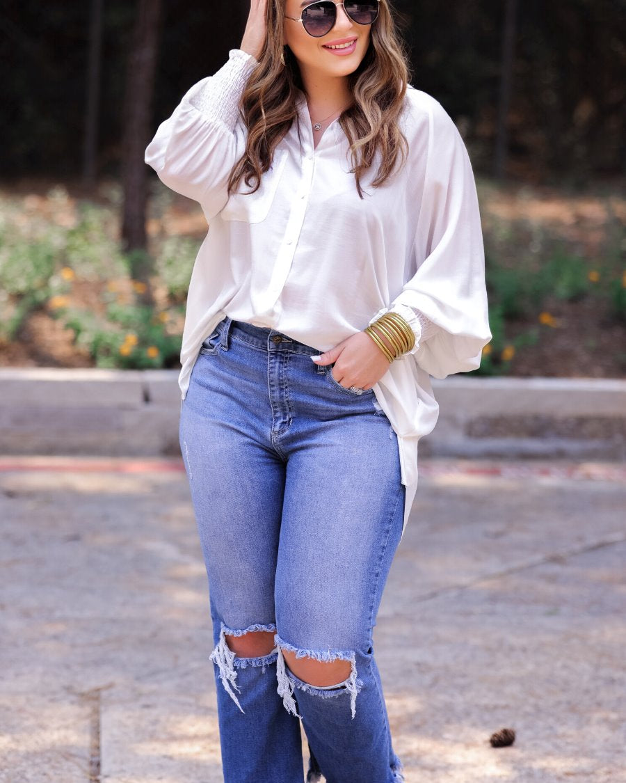 long-sleeve unlined top with a collared neckline, smocked wrists, button down front closure, functional side pockets, a chest pocket, a high-low hemline, and a relaxed fit designed on vertical stripe fabric in ivory