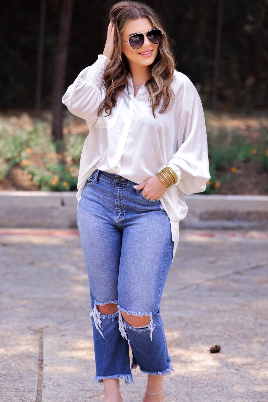 long-sleeve unlined top with a collared neckline, smocked wrists, button down front closure, functional side pockets, a chest pocket, a high-low hemline, and a relaxed fit designed on vertical stripe fabric in ivory