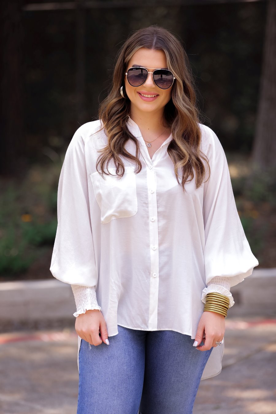 long-sleeve unlined top with a collared neckline, smocked wrists, button down front closure, functional side pockets, a chest pocket, a high-low hemline, and a relaxed fit designed on vertical stripe fabric in ivory