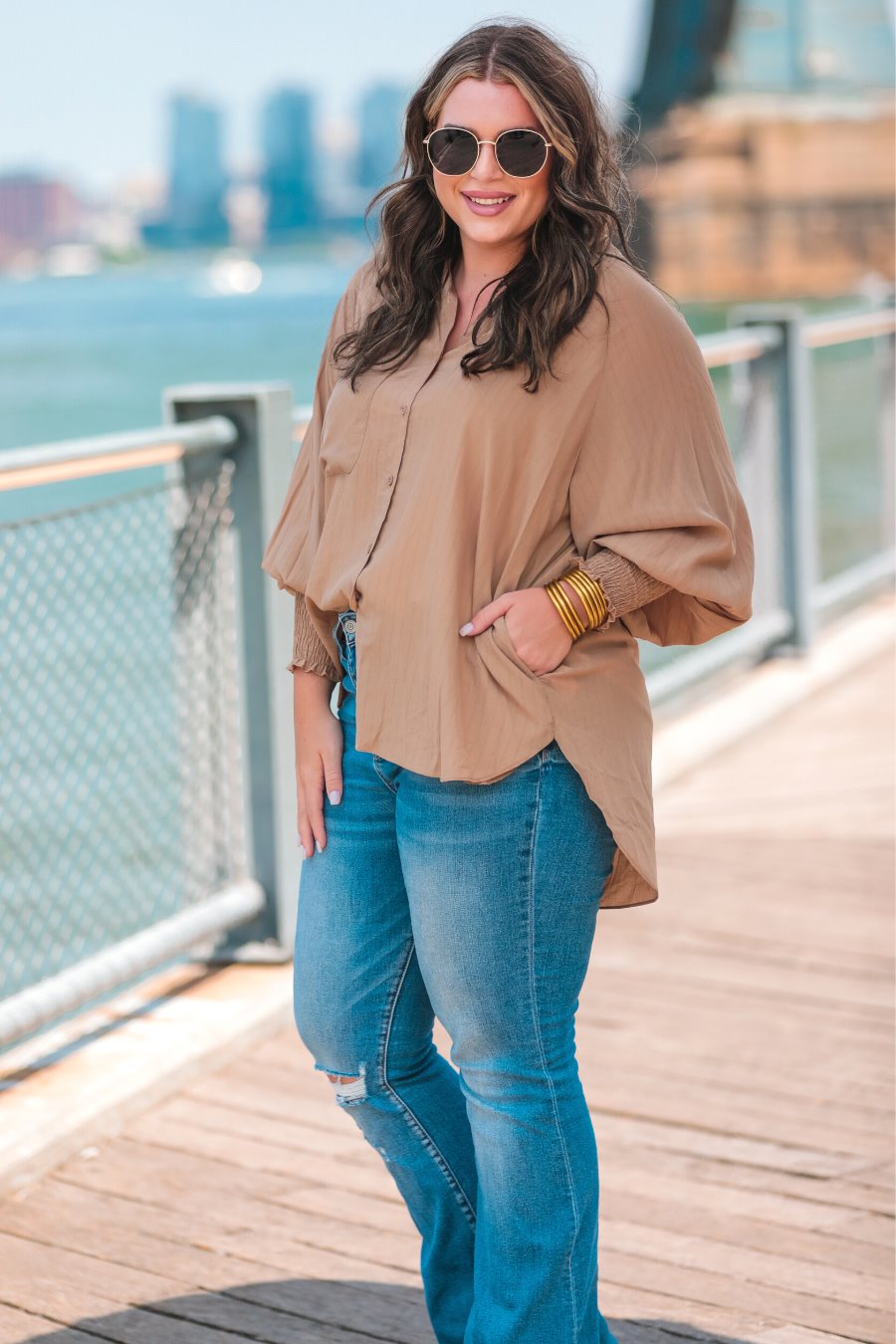 long-sleeve unlined top with a collared neckline, smocked wrists, button down front closure, functional side pockets, a chest pocket, a high-low hemline, and a relaxed fit designed on vertical stripe fabric in taupe